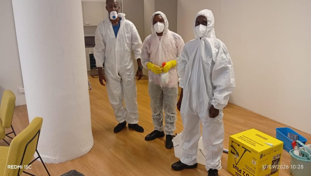 Techniciens en combinaison avant désinfection d'une cuisine à Paris